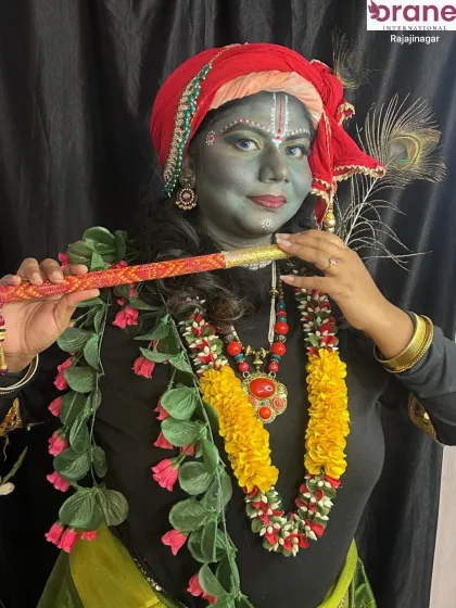 The classic pose with a flute completes the Krishna transformation, a perfect example of character portrayal through makeup.