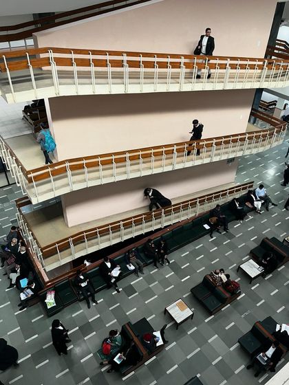 A view of the bustling corridors inside a court building. This is the daily reality of litigation: lawyers and clients waiting, preparing, and moving through the halls of justice.