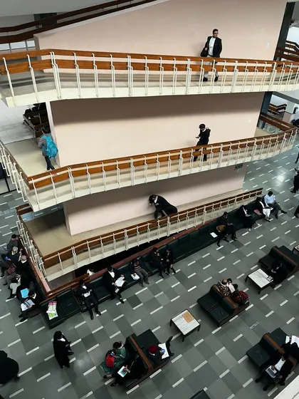 A view of the bustling corridors inside a court building. This is the daily reality of litigation: lawyers and clients waiting, preparing, and moving through the halls of justice.