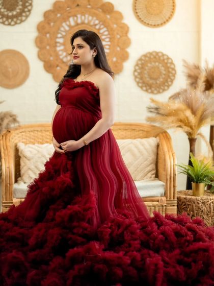 A standing portrait showcasing the elegance of the red gown and the beauty of the mom-to-be.