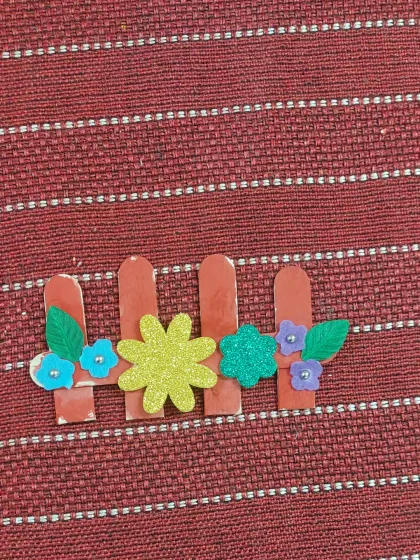 This simple but lovely garden fence was made using popsicle sticks and foam flowers. It's a great example of the simple, accessible crafts we do in our workshops.