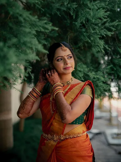 A candid moment of the bride adjusting her earring, her profile looking elegant.