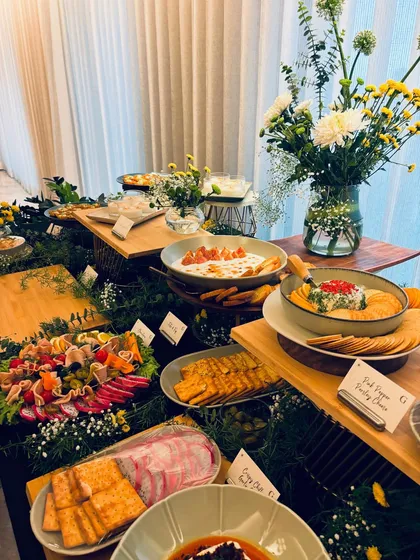 A lush and abundant grazing table set for a pre-Rakhi celebration. This spread features a mix of our signature Asian non-veg specials and vibrant vegetarian creations, including a charcuterie board and various dips.
