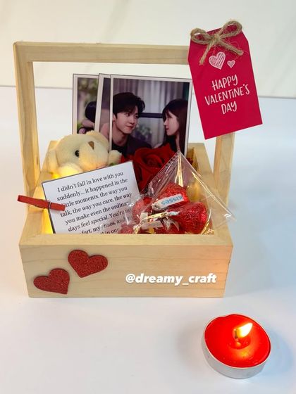 Another angle of the wooden basket hamper for Valentine's Day. The combination of personal photos, a handwritten note, and a single rose makes it a very heartfelt gift.