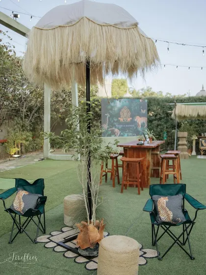 We created various seating zones for the safari sundowner, including this casual setup with camping chairs and a thatched umbrella, perfect for a relaxed evening under the stars.