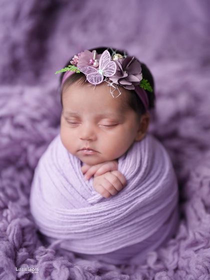 A cozy potato sack pose in a lovely shade of light purple. The butterfly on the headband adds a touch of whimsy.