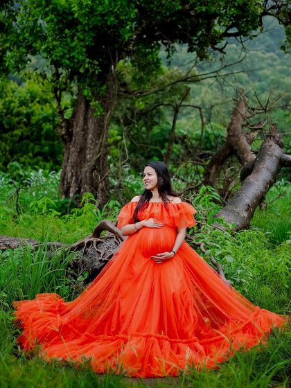 A serene moment in the forest with our orange ball gown. The vibrant color pops against the deep greens, creating a magical, fairytale-like portrait.