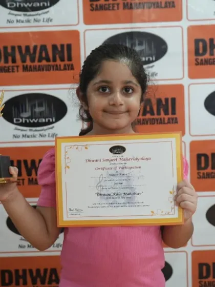 A young achiever from our beginner painting classes with her well-earned certificate and trophy.