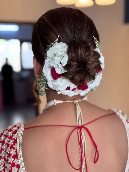 A detailed shot of the red and white floral bun, perfect for a traditional wedding.