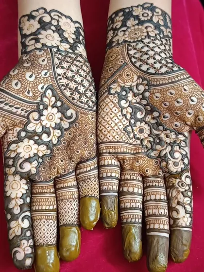 A full view of the reverse-fill floral design. The contrast between the dark henna and the delicate white flowers is striking, offering a modern twist on bridal mehendi.