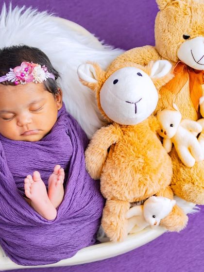 This setup combines the purple swaddle with cuddly teddy bears, adding a layer of sweetness and comfort to the portrait.