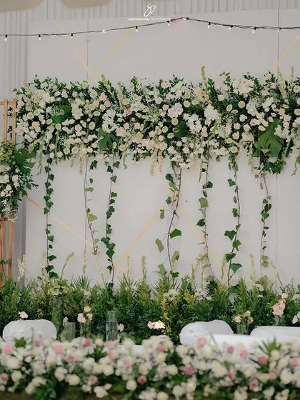 We crafted this breathtaking engagement stage using a lush arrangement of white florals and cascading ivy. The design combines natural textures with clean lines to create a backdrop that is both modern and timelessly elegant.
