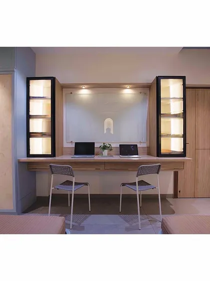 The other side of the teens' room features a large, shared study desk and custom wardrobes, ensuring plenty of space for both schoolwork and storage.