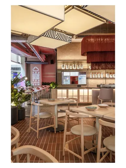 This perspective shows the harmony between different lighting sources, from the large patterned lanterns to the dramatic red tassel chandelier and the soft glow of the bar. Each light source is chosen to define a zone and contribute to the overall mood.