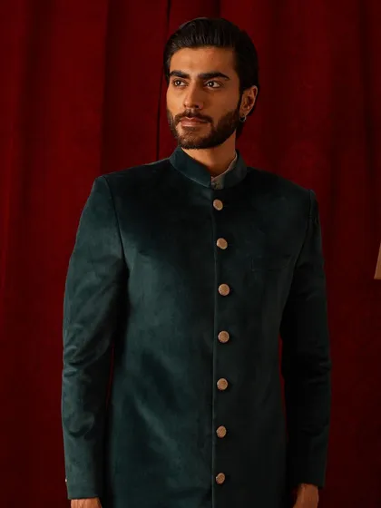 This deep green velvet bandhgala is a study in classic sophistication. The rich color and plush texture make it a luxurious choice for winter festivities and formal dinners.