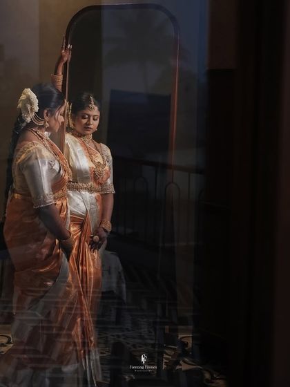 A beautifully lit portrait of the new mother looking at her reflection. The play of light and shadow adds a dramatic and artistic quality to this photo from the naming ceremony.