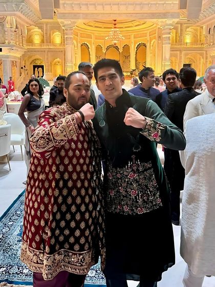 Vijender Singh with Anant Ambani, showcasing the intricate hand-embroidery and luxurious velvet of his green Jawahar jacket.
