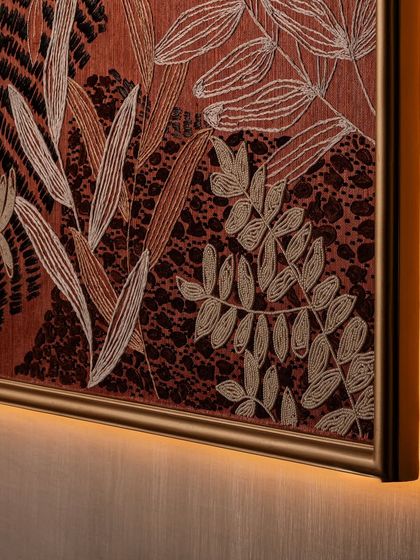This is not just wallpaper; it is artwork in thread. Our custom-designed embroidered wallpaper, seen here framed and backlit, was created by master artisans. It brings texture, warmth, and quiet drama to the boutique's most indulgent zone.