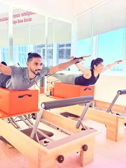 The Swan exercise performed in sync. This move strengthens the entire back of the body and requires deep core engagement from both partners to stay coordinated.