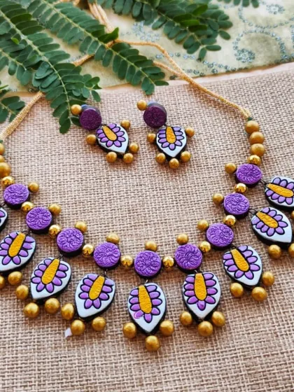 This beautiful, lightweight necklace features a two-layer design with a leaf-patterned hanging charm. This version is in a lovely purple, silver, gold, and yellow combination.