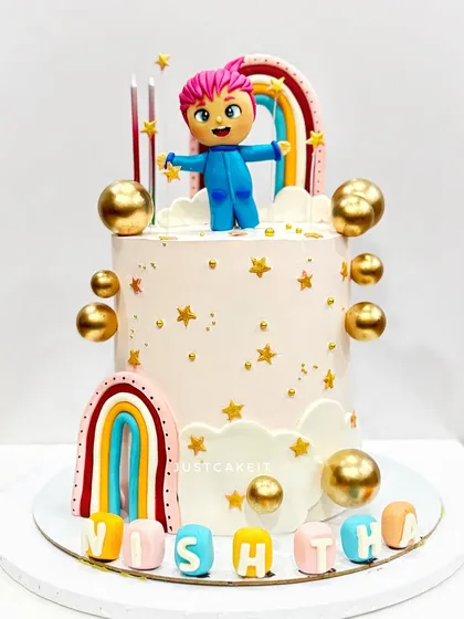 A cute cake based on the 'Bebefinn' character. The design features a hand-molded figurine, rainbows, and golden stars for a magical touch.