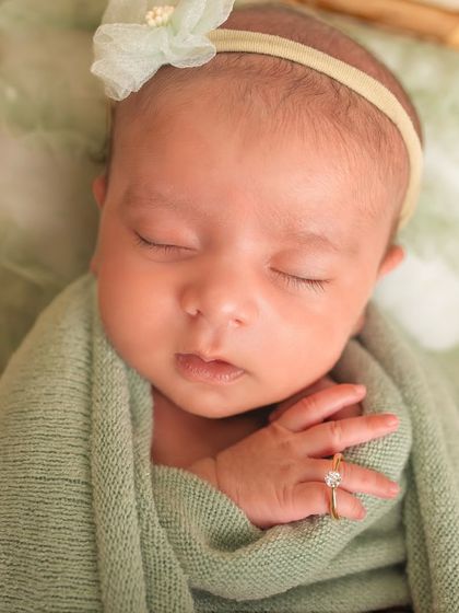 The tiniest details are the most precious. A close-up of a newborn's hand, with her mother's engagement ring showing just how small she is.