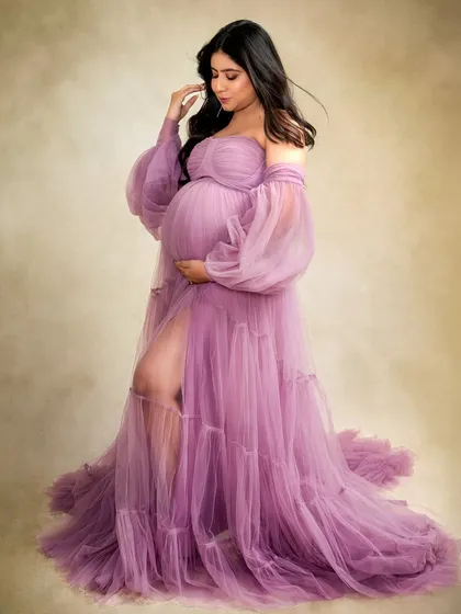 This mumma-to-be looks absolutely radiant in a flowing purple gown from my studio collection. The off-shoulder style and sheer fabric add a touch of romance and drama.
