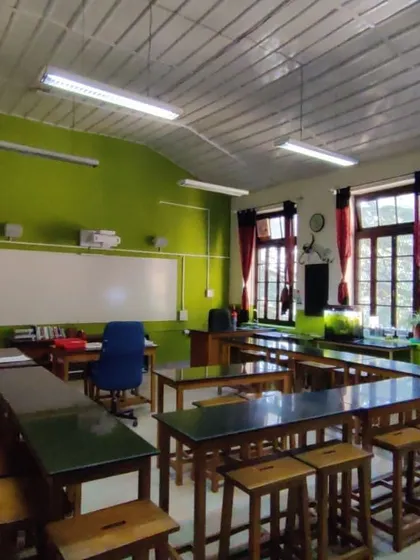 The previous biology lab space, characterized by dated green walls and rigid furniture layouts that hindered collaborative learning.