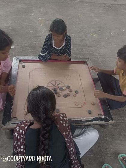 A game of carrom in progress at the Makkala Masti summer camp. We believe in the importance of play and social interaction.