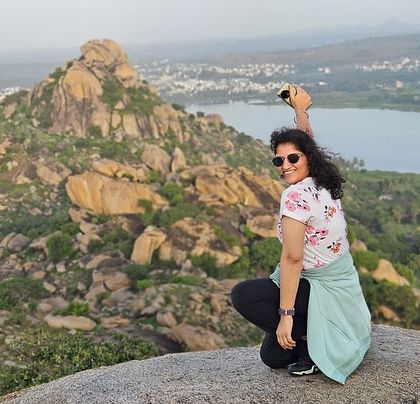 A solo trekker posing against the stunning backdrop of Kunti Betta.
