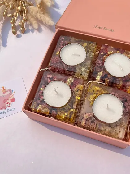 A set of four square resin tea light holders, filled with preserved flowers, presented in a beautiful gift box.