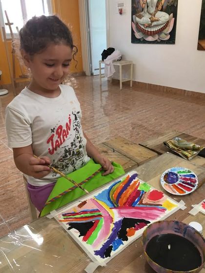 Another shot of our abstract expressionist, Lina, deeply focused on her vibrant acrylic masterpiece.