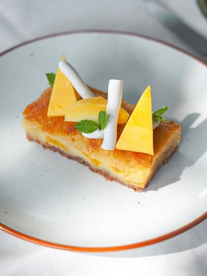 A sweet ending to our summer menu. This dessert features a light cake base topped with fresh seasonal mango and coconut, a perfect tropical treat.