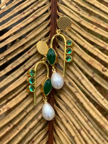 Another angle of the green and pearl brass earrings, showing their delicate structure and beautiful shine.