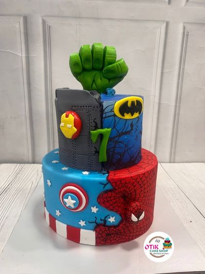 This two-tiered cake unites the greatest superheroes for a 7th birthday. We combined the worlds of Marvel and DC, featuring fondant details for Spider-Man, Captain America, Batman, and the Hulk's mighty fist.