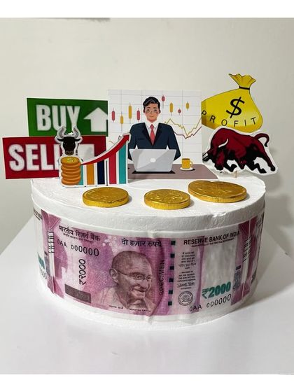 A custom half-kg Ferrero Rocher cake for a stock trader. The cake is decorated with edible money prints and toppers representing the stock market bull and "Buy/Sell" signs.