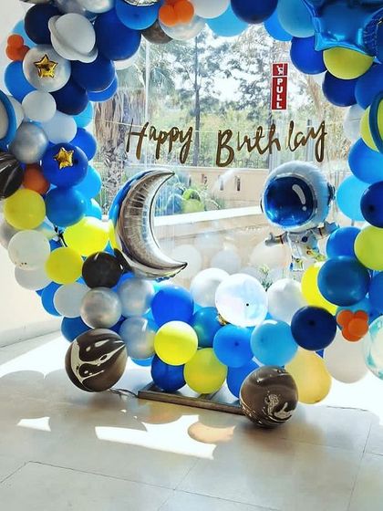 A circular balloon arch creating a portal to a space adventure. This setup for a birthday party is filled with planet and moon balloons, perfect for cosmic-themed photos.