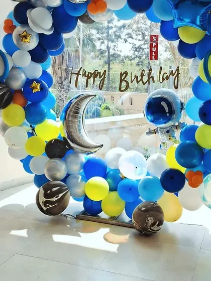 A circular balloon arch creating a portal to a space adventure. This setup for a birthday party is filled with planet and moon balloons, perfect for cosmic-themed photos.