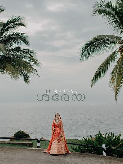 A stunning wide-angle portrait of Shreya in Kerala. The palm trees and the sea provide a breathtaking backdrop, perfectly capturing the essence of a tropical destination wedding.
