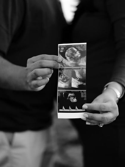 A simple and powerful black and white close-up of the couple holding the sonogram pictures together. Their hands and the first images of their baby are the complete story.