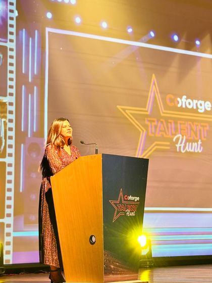 At the podium during the Coforge Talent Hunt. I ensure the competition runs smoothly, giving each performer their moment to shine.