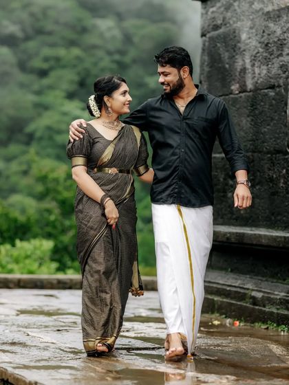A couple in traditional South Indian attire shares a walk in the rain, creating a romantic and memorable pre-wedding photograph.