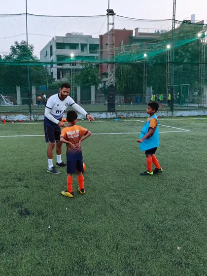 Nurturing the next generation of soccer stars. A coach gives specific instructions to two players during a training session.