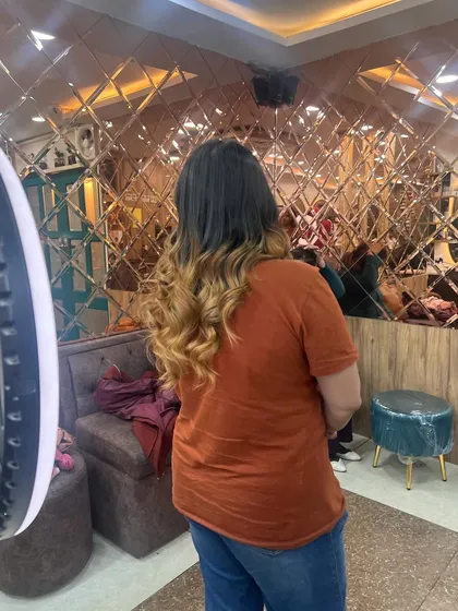 Another angle of the beautiful blonde ombre, showing how the color looks against our salon's modern, reflective wall.