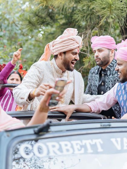 The groom's baraat is full of energy and laughter as he arrives in a jeep at his Corbett wedding.