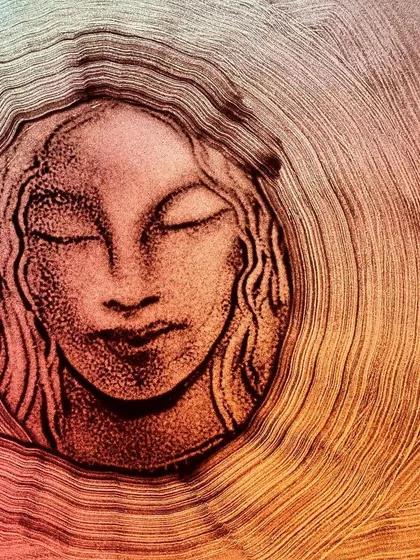 This sand painting, titled 'Circles', is an example of my fine art work. It explores themes of femininity and inner peace, using the natural texture of sand to create a piece that is both visually striking and emotionally resonant.