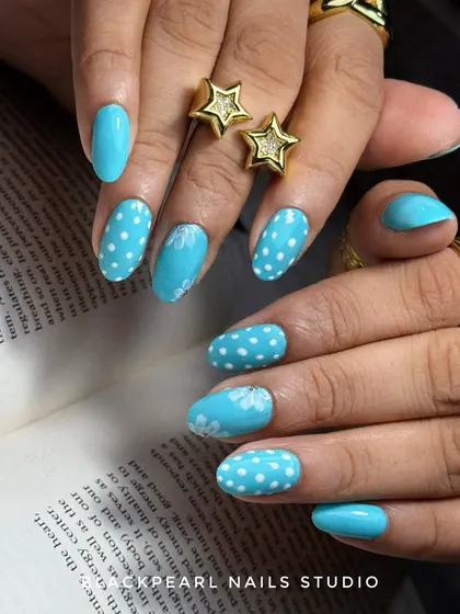 A classy and trendy design featuring aqua blue polish with polka dots and soft, hand-painted flowers. This set combines a popular pattern with delicate art for a look of pure elegance.