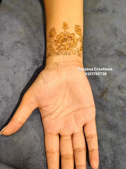 A delicate floral band on the wrist, perfect for someone who wants a small, temporary henna tattoo.