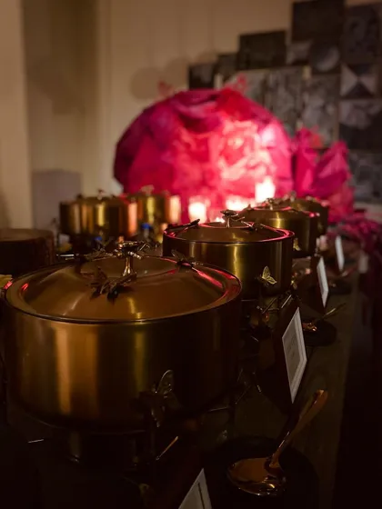 A moodily lit shot of our Diwali buffet, with candles creating a warm and inviting glow on the golden serving dishes.