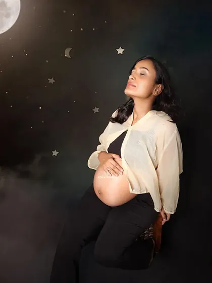 Wishing on a star for you. This creative portrait places the mom-to-be in a celestial setting, sitting among the moon and stars, capturing the wonder and magic of waiting for her baby.